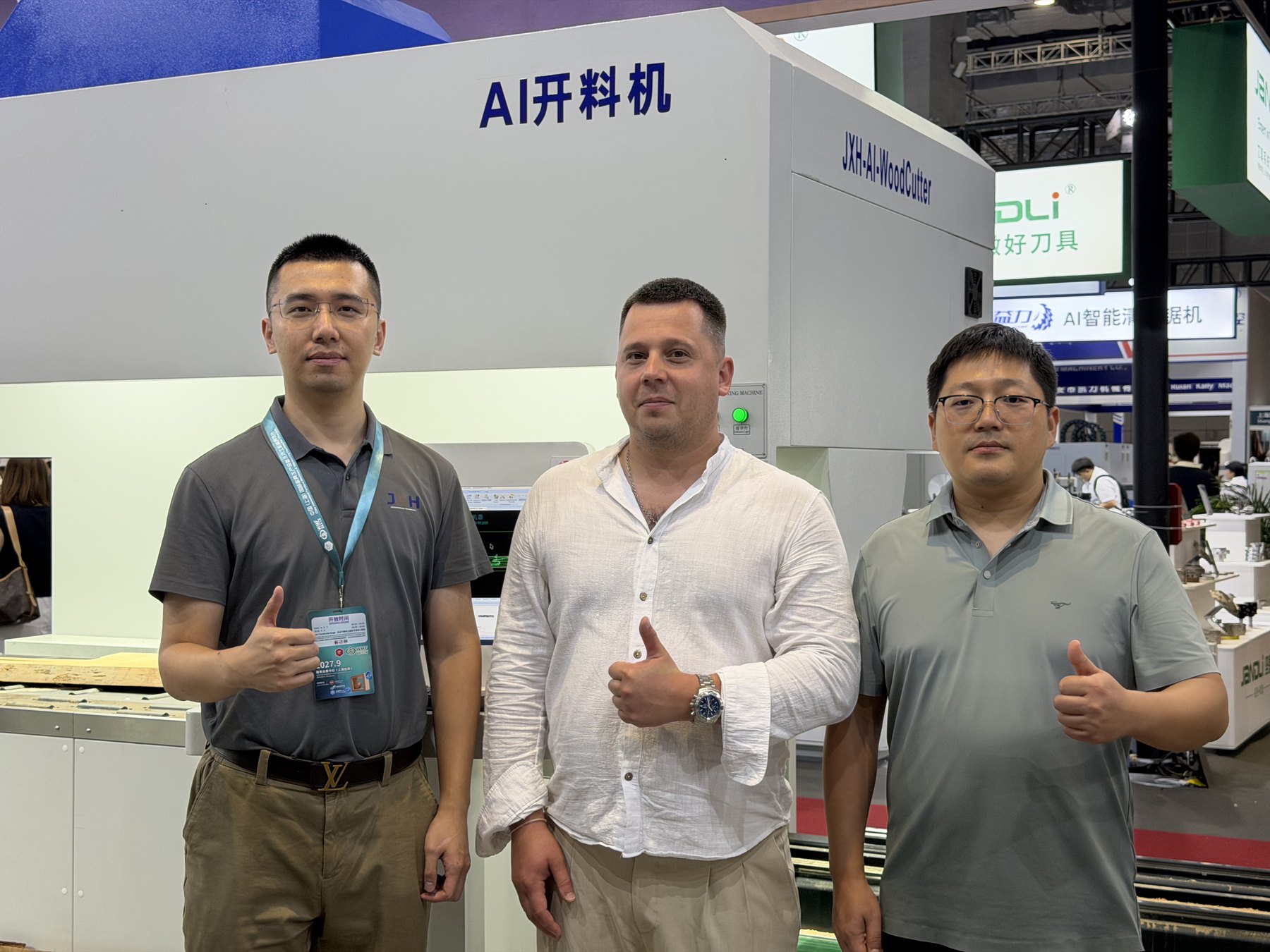 JXH team with an overseas customer beside the One-to-Two AI Cutting Machine